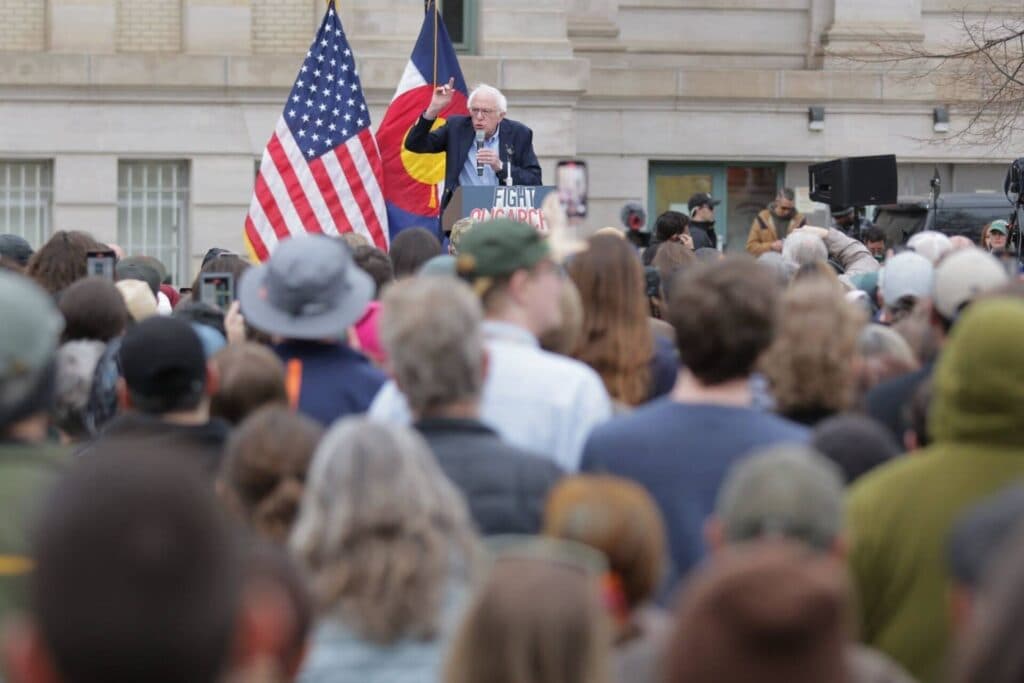 Bernie Sanders speaks at a podium reading &quot;Fight Oligarchy.&quot;